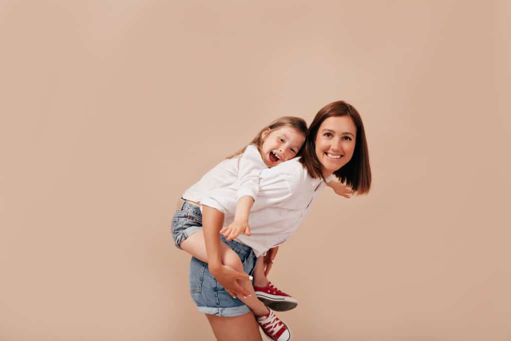 Smiling mother carrying her joyful daughter on her back, creating a loving and playful bond.