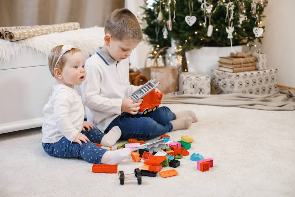 Two siblings playing together, a helpful tip for getting strong-willed children to cooperate