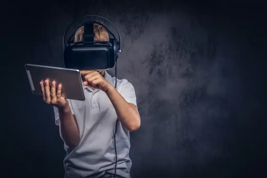 video game addiction - boy with virtual reality glasses playing a game
