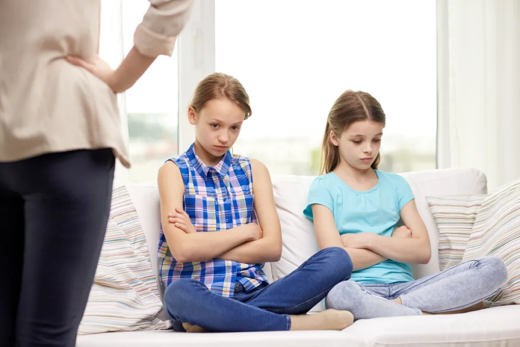 Sisters being scolded by an authoritarian mom