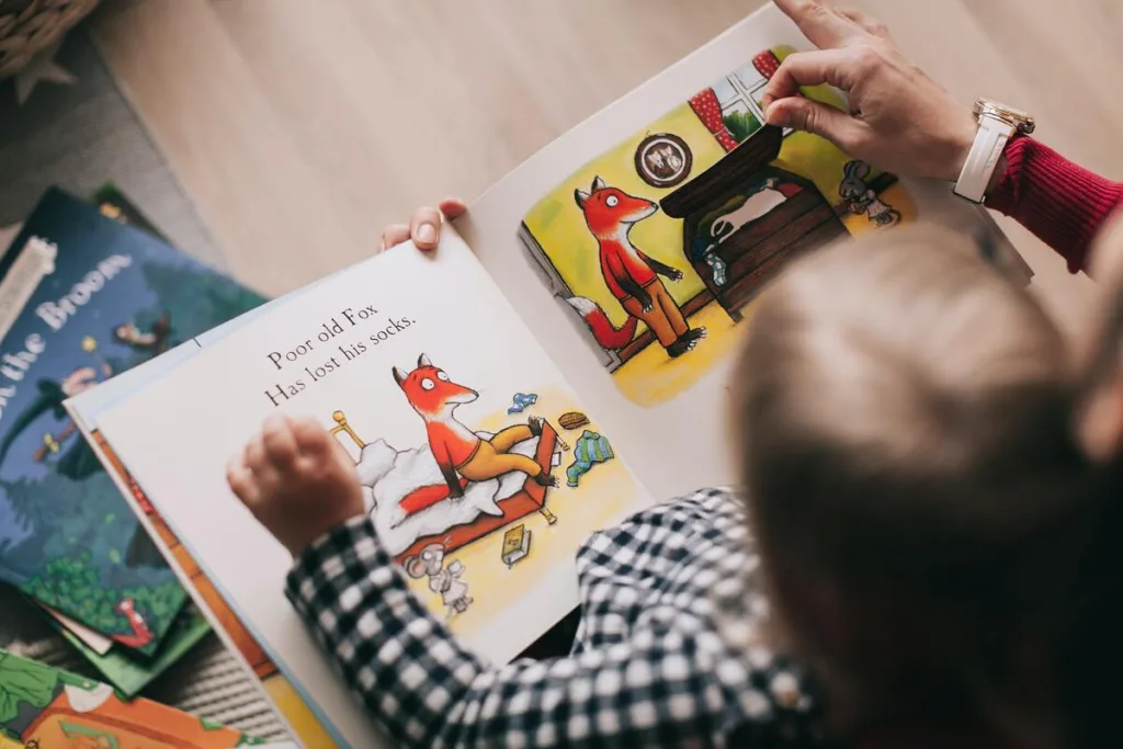 Picture from above of a mother reading a book about a fox to her toddler