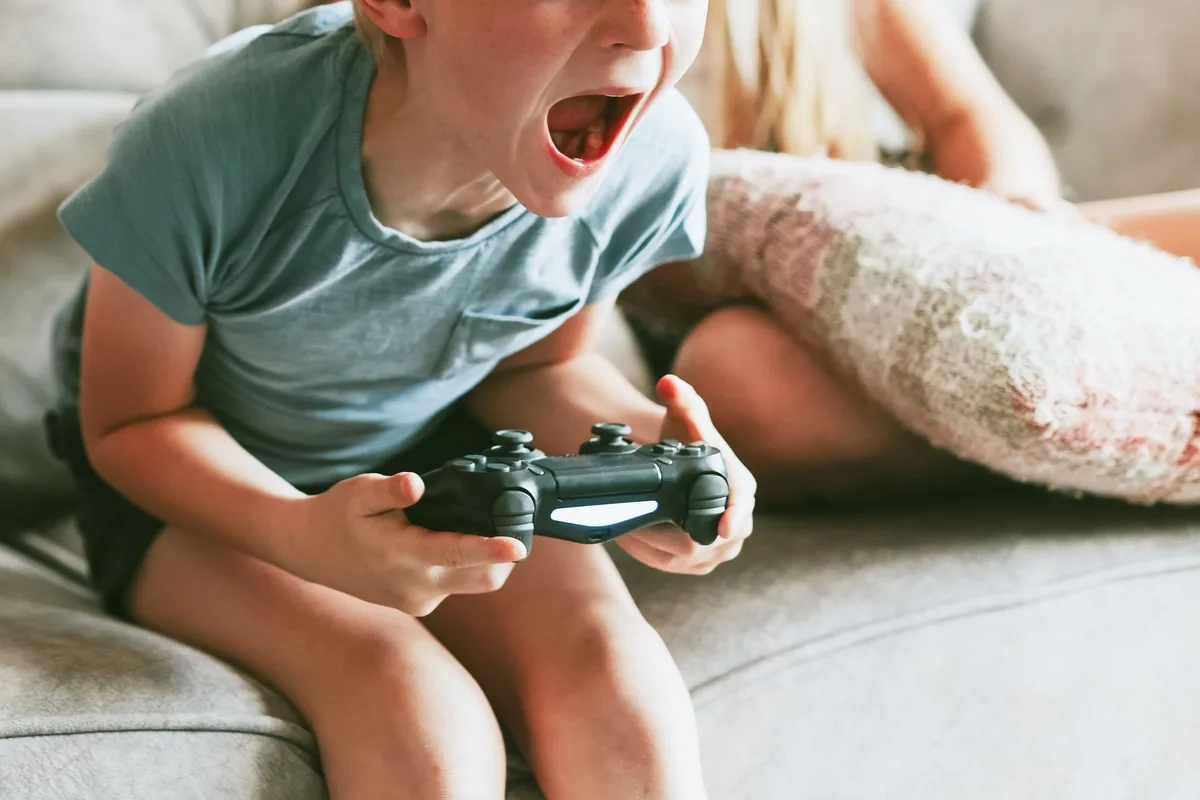 Tense boy yelling holding a video game controller