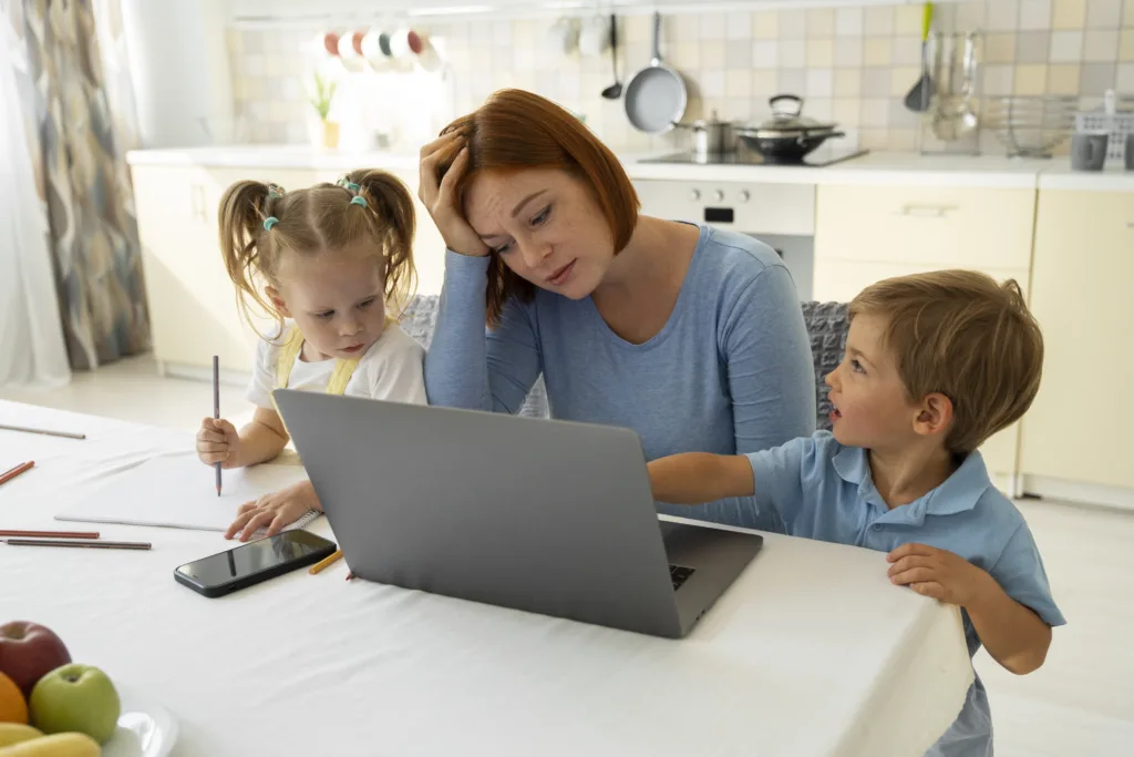 Mother trying to work on the laptop, but kids keep interrupting