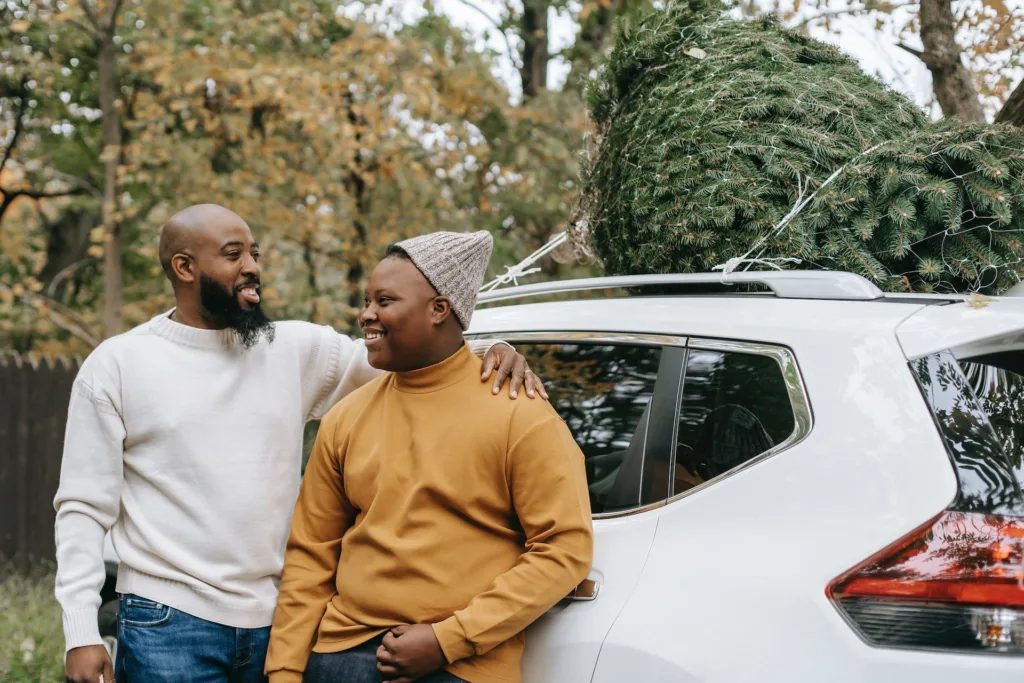 dad and son smiling at each other, after buying together the christmas tree