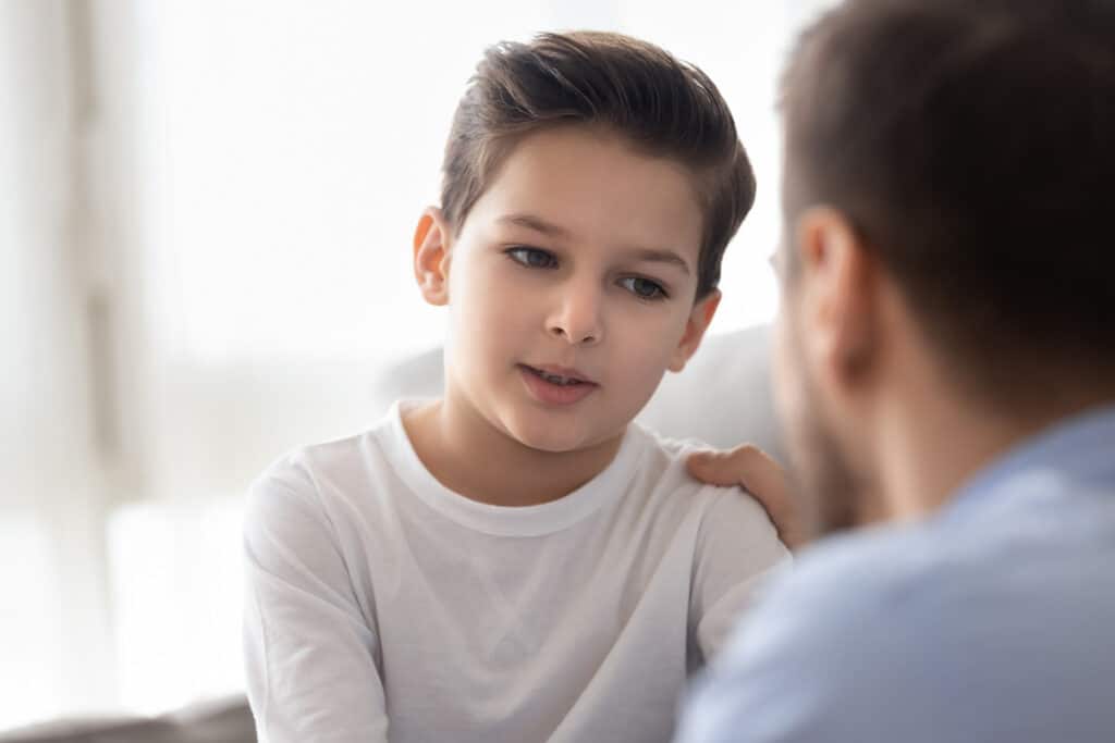 Why parents should not be friends with their child - dad gently touches his son's arm while talking