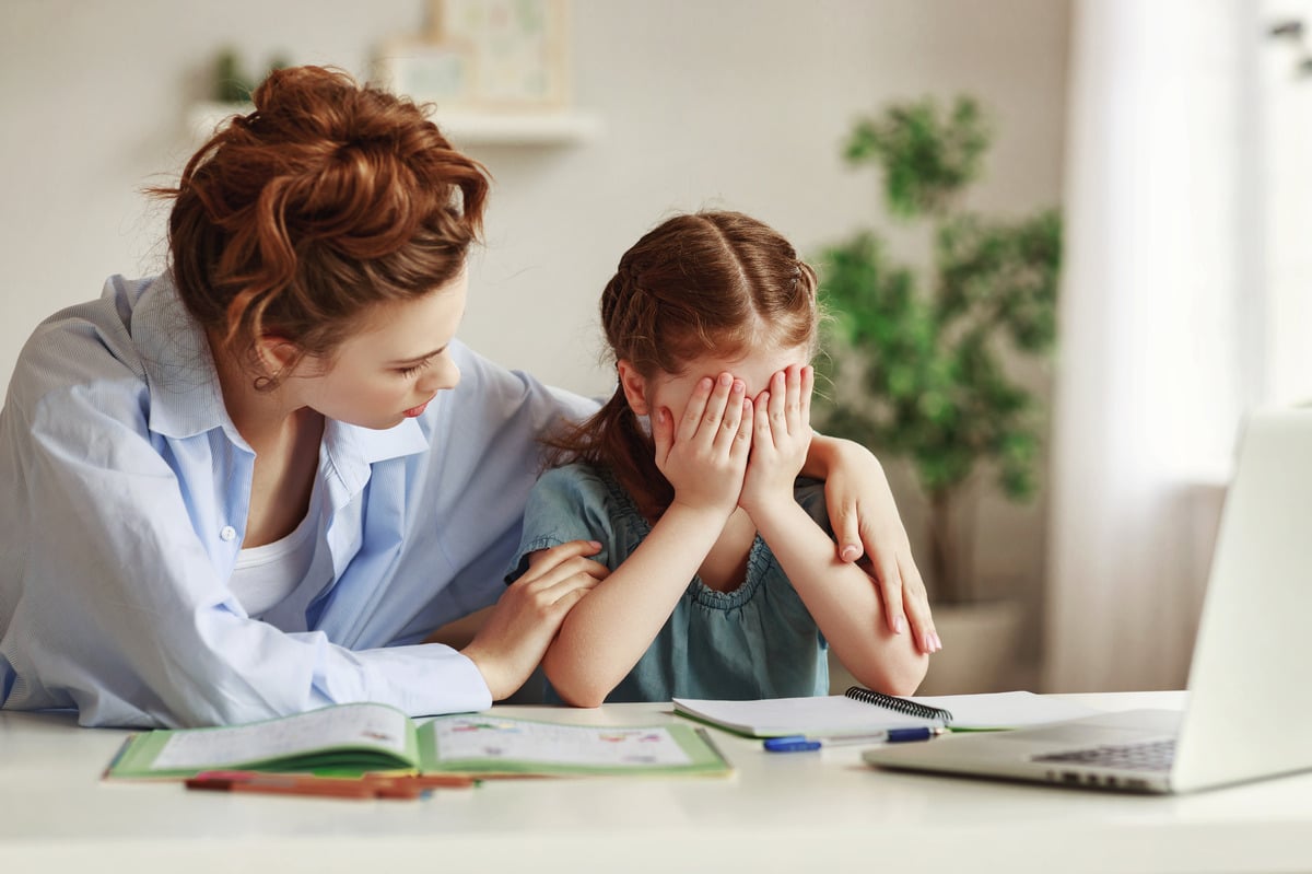 kid doing homework with mom