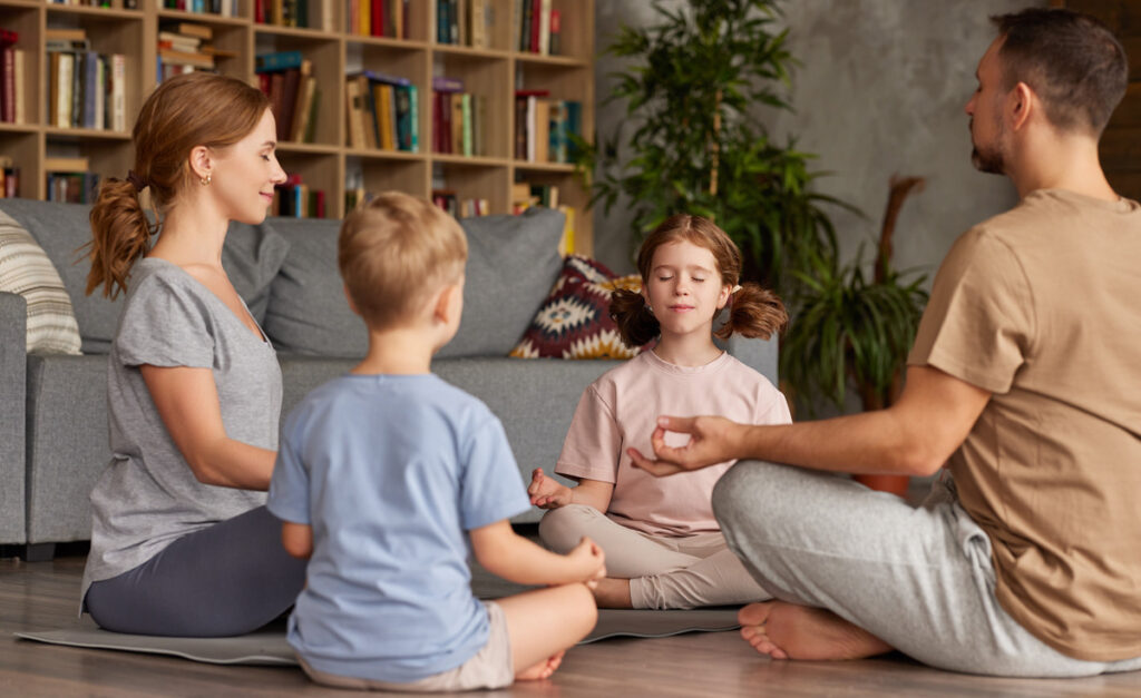 Young family of four taking a moment to relax and meditate